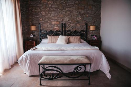 1 dormitorio con 1 cama grande y pared de piedra en Cal Majoral, en L'Espunyola