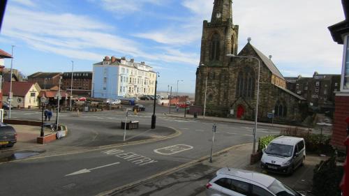 una calle con coches aparcados frente a una iglesia en Longcroft Lodge, en Bridlington