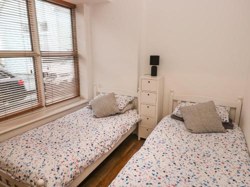 sypialnia z 2 łóżkami pojedynczymi i oknem w obiekcie Smugglers Cottage w mieście Saundersfoot
