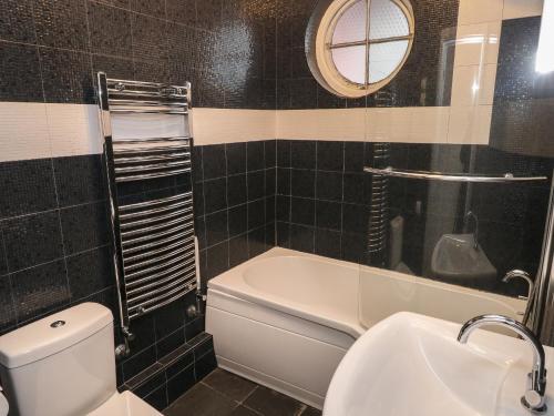 W łazience znajduje się toaleta, umywalka i lustro. w obiekcie Smugglers Cottage w mieście Saundersfoot