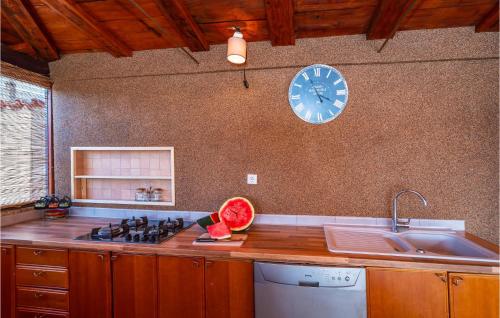 a kitchen with a sink and a clock on the wall at Amazing Home In Galovac With 6 Bedrooms, Wifi And Outdoor Swimming Pool in Galovac