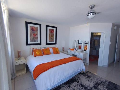 una camera da letto con un grande letto con cuscini arancioni di Luxury 4 bedroom apartment a Margate