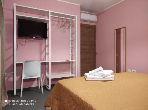 a bedroom with a bed with a tv and a shelf at bbnapl'est in Naples
