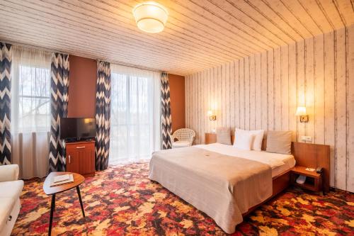 ein Hotelzimmer mit einem Bett und einem großen Fenster in der Unterkunft Hotel Lajta Park in Mosonmagyaróvár