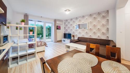 a living room with a couch and a table at Willa Park, Sun & Snow in Dziwnów