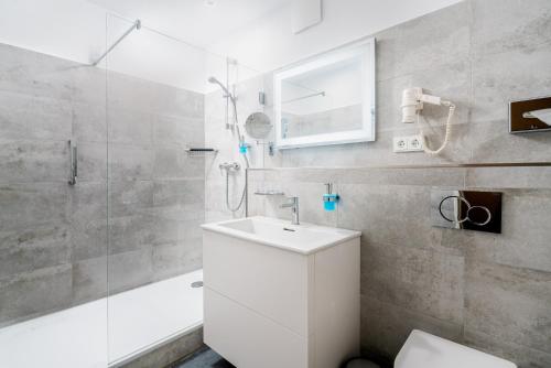 a bathroom with a white sink and a shower at Hotel Bellevue in Timmendorfer Strand