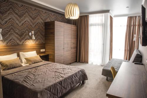 Habitación de hotel con cama, escritorio y habitación en Guest House Venezia, en Anapa