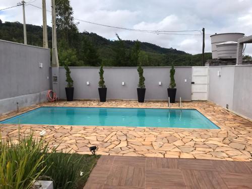 塞拉內格拉的住宿－tranquilidade，庭院内种植了盆栽植物的游泳池