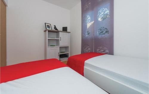 two beds in a bedroom with white and red at Cozy Apartment In Vodice With House Sea View in Vodice
