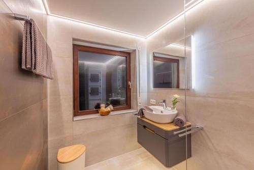 a bathroom with a sink and a window at Comfort Apartment Buchhorn in Friedrichshafen