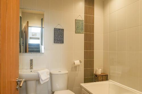 a bathroom with a toilet and a sink and a mirror at Hazelmere - Woolacombe-4 Bed-Sleeps 10-TJSHH in Woolacombe