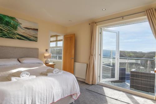 a bedroom with a bed and a large window at Hazelmere - Woolacombe-4 Bed-Sleeps 10-TJSHH in Woolacombe