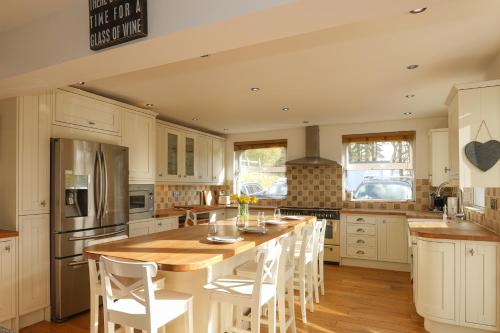 a kitchen with a large wooden table and white cabinets at Hazelmere House in Woolacombe
