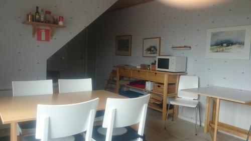 uma sala de jantar com uma mesa e cadeiras brancas em Branteviks Viste em Brantevik