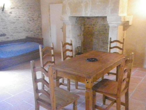 a dining room with a wooden table and chairs at Manoir de la Baronnie in Marcei
