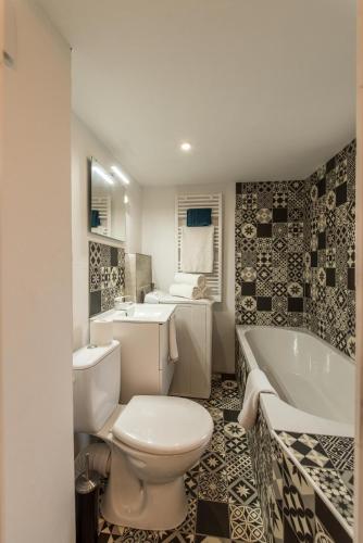 une salle de bain avec toilettes, baignoire et lavabo dans l'établissement L'Escale Bohème - Centre historique de Sélestat, à Sélestat