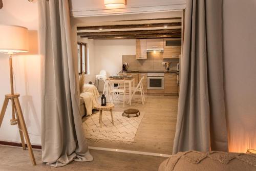 セレスタにあるL'Escale Bohème - Centre historique de Sélestatのキッチン、リビングルーム(カーテン付)が備わります。