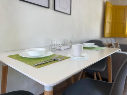 a white table with two cups and plates on it at Palmar de Jericó Suites in Jericó