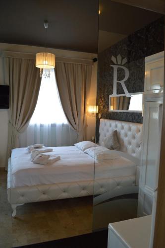 a bedroom with a large white bed with a window at Hotel RICHTR in Frýdek-Místek