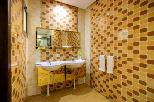 Hospitality Path Serviced Apartments في الرياض: حمام مع حوض ومرآة