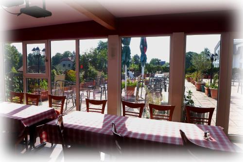 ein Restaurant mit Tischen und Stühlen und Blick auf den Innenhof in der Unterkunft Hotel Lindenberger Hof in Ahrensfelde