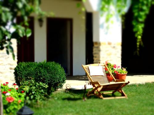 a wooden bench sitting in the grass in a yard at Osmarski Houses in Osmar