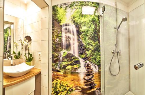 a bathroom with a shower with a waterfall mural at Wohlfühl-Ferienwohnungen Kirchberger in Bodenmais