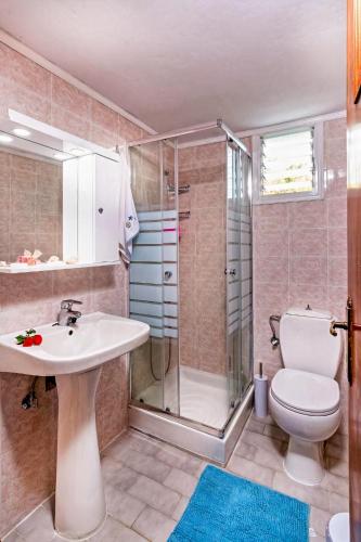 a bathroom with a toilet and a sink and a shower at Blue Beach House in Kissamos