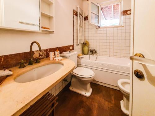 Un baño con lavabo, inodoro y bañera. en Casa Zuccale, en Capoliveri