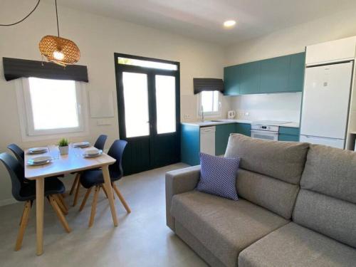 sala de estar con sofá, mesa y cocina en Apartamento Sa Mesquida 7, en Cala Llonga