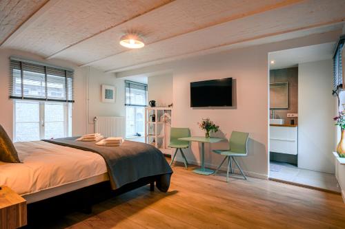 a bedroom with a bed and a table with chairs at B&B Gracht 62 in Maastricht