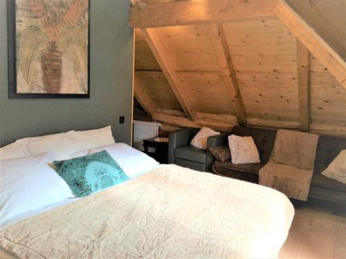 a bedroom with a white bed and a chair at LES CHALET Kranjska Gora DUPLEX in Kranjska Gora