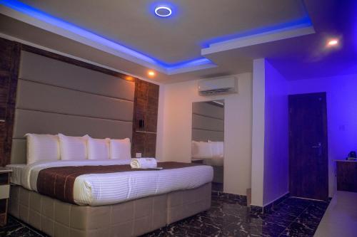 a hotel room with a large bed with purple lights at PRESKEN HOTELS @FAJODD-4 in Ikeja