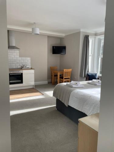 a bedroom with a bed and a kitchen and a table at Braemar in Falmouth
