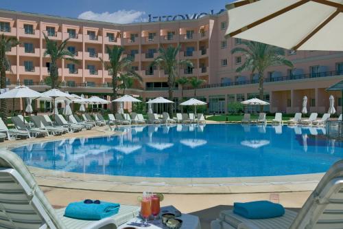 a large swimming pool in front of a hotel at Novotel Cairo 6th Of October in 6th Of October
