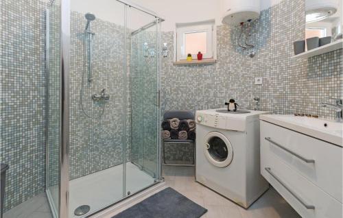 ein Bad mit einer Waschmaschine und einer Dusche in der Unterkunft 3 Bedroom Nice Home In Vodnjan in Vodnjan