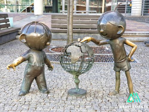 a statue of two children playing with a globe at APARTAMENTY SZYNDZIELNIA ROWERY GÓRY Spacery in Bielsko-Biala