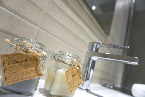 een glazen pot zeep op een wastafel bij PANORAMA MAR - Primera Linea - Lujo in Torrevieja