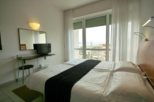 a bedroom with a bed and a desk and a window at Hotel L'Approdo in Rapallo