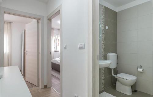La salle de bains blanche est pourvue de toilettes et d'un lavabo. dans l'établissement 2 Bedroom Gorgeous Apartment In Vodnjan, à Vodnjan