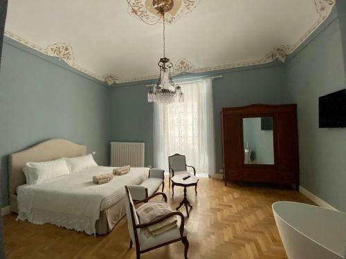 a bedroom with a bed and a chair and a mirror at Dimora delle Maestranze (Ortigia) in Siracusa