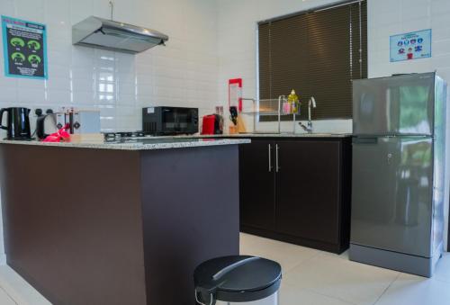 a kitchen with a counter and a refrigerator at Hidden Valley Residence in Au Cap