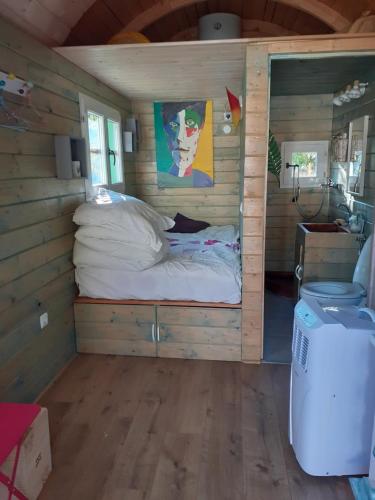 a bedroom in a log cabin with a bed in it at Roulotte au numero 886 in Salernes