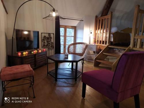 uma sala de estar com uma mesa e uma cadeira em Gîte Baie Bonheur em Genêts