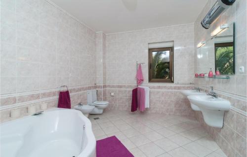 a bathroom with two toilets and a tub and sink at 2 Bedroom Lovely Apartment In Bol in Bol