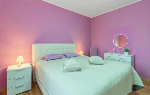a purple bedroom with a white bed and a mirror at Awesome Apartment In Fazana With Outdoor Swimming Pool in Štinjan