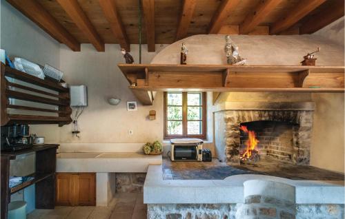 a kitchen with a stone fireplace in a room at 2 Bedroom Pet Friendly Home In Postira in Postira