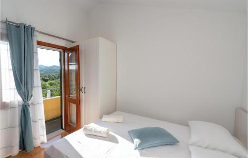 a white bedroom with a bed and a window at Pet Friendly Home In Cara in Zavalatica