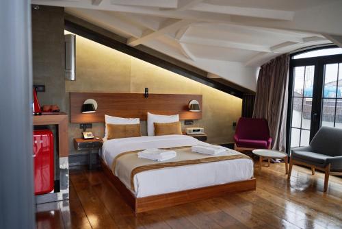 a bedroom with a large bed and a chair in it at Hotel The Public - Special Category in Istanbul