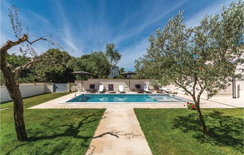 a swimming pool in a yard with trees at Nice Apartment In Stinjan With Outdoor Swimming Pool in Štinjan